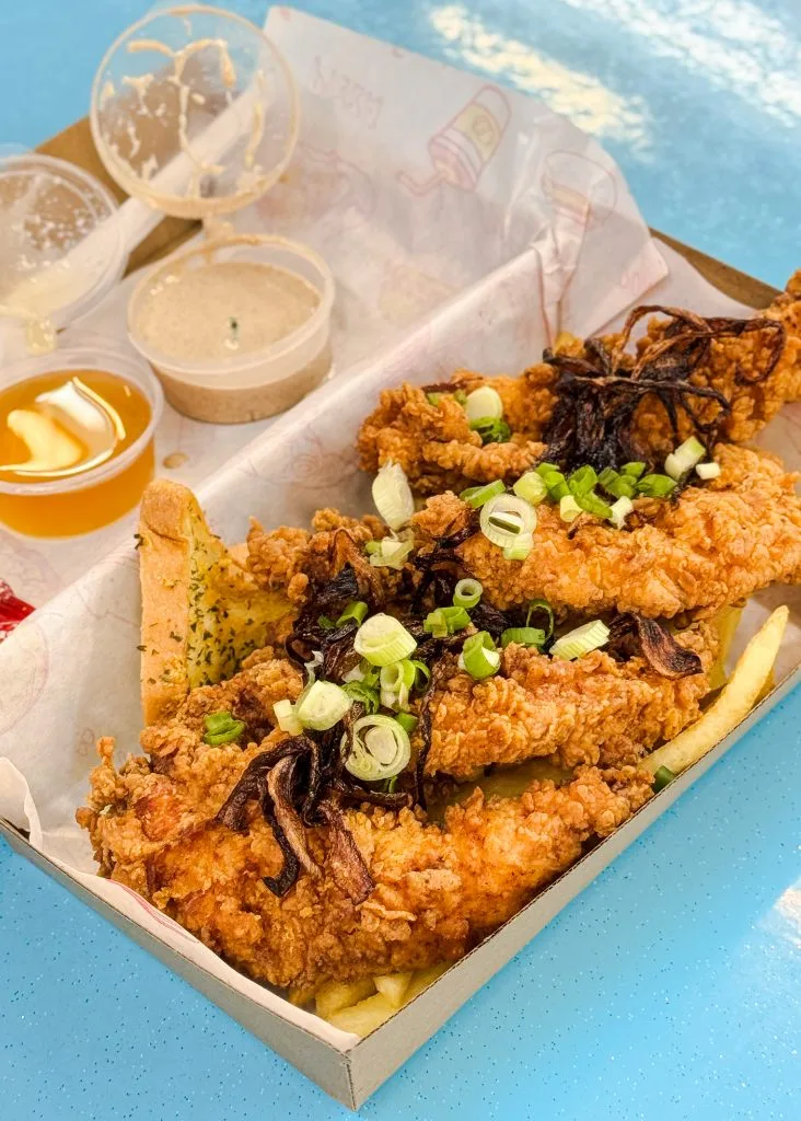 Last Bite Western's Dirty OG Loaded box, buttermilk chicken tenders over fries with charred onions, spring onions, garlic bread, honey and dipping sauces